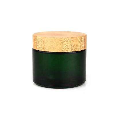 China Custom Empty Personal Care Products Face Cream Containers 100ml Green Frosted Glass Cosmetic Jars Container With Bamboo Lid for sale