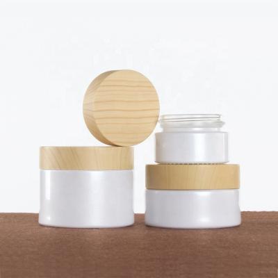 China Low MOQ 20g 30g 50g Eco-friendly Recyclable White Glass Cosmetic Cream Jar With Wood Grain Cap for sale