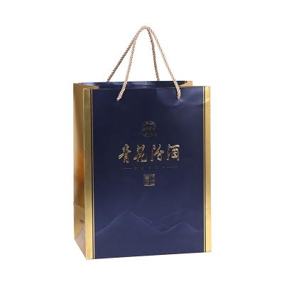 China Recycled Materials Wholesale Hot Stamping UV Printed Packaging Paper Bags Custom Gold Rope Handle Wine Gift Bags for sale