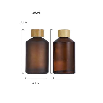 China Luxury 200ml cosmetic packaging cosmetics frosted slant shoulder amber glass serum lotion bottles with bamboo cap for sale