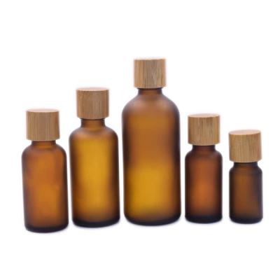 China Wholesale Personal Care Amber Brown Frosted Essential Oil Bottles 15ml 20ml30ml 50ml 100ml Cosmetic Glass Oil Bottle With Bamboo Lid for sale