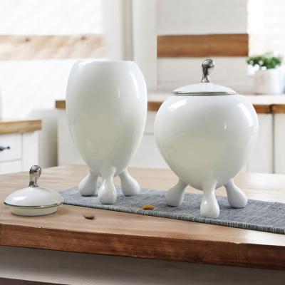 China With a lid European minimalist oval porcelain tripod style candy canister nut storage ceramic desktop jar with lid for sale