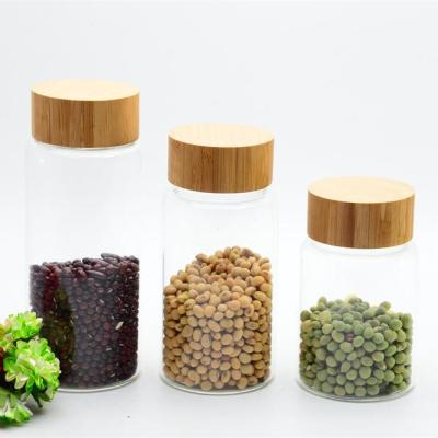 China Stocked Borosilicate Round Glass Water Bottle With Bamboo Lid for sale