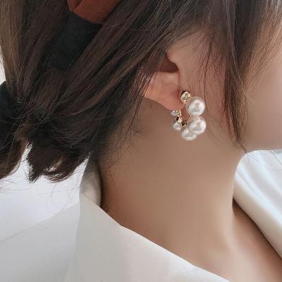 China Fashionable hot premium c-shaped temperament pearl sense selling red pearl stud earrings for woman for sale