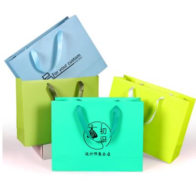 China Recyclable Custom Luxury Gold Stamping Shopping Carrier White Cardboard Paper Bag With Ribbon Handle for sale