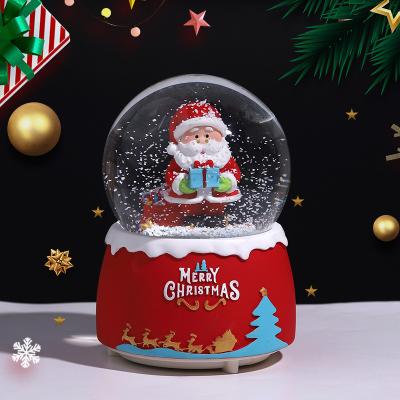 China 2023 Folk Art Santa Claus Crystal Ball Resin Ornaments With Light And Music Snow Hotel Ornaments Christmas Gift Souvenirs for sale