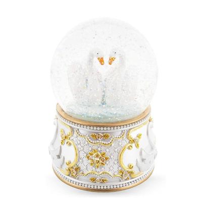 China Europe wedding gift swan couples snow globe with custom ornament resin swan glass blowing snow globes watering globes for sale