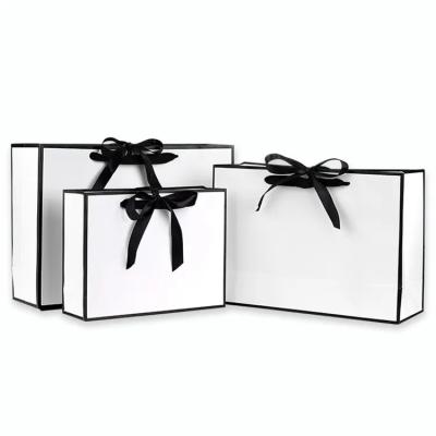 China Black Luxury Disposable Retail Quality Gift Shopping Paper Bags And Wedding Favor Bags With Handles And Bow for sale