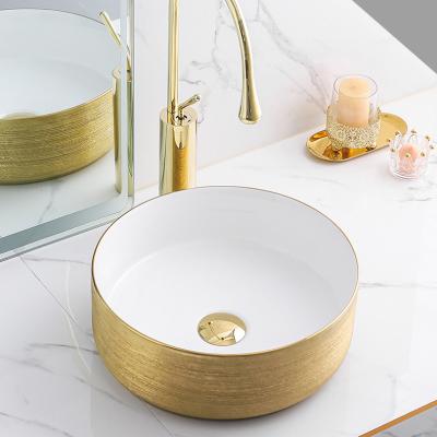 China Easy Clean Luxury Decorative Artistic Round Basin Bathroom Table Top Wash White Ceramic Gold Brushed Sink With Faucet for sale