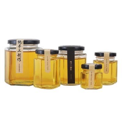 China Wholesale Empty Clear Glass Food Storage Jar Hexagonal Food Honey Jar Glass With Metal Lid for sale