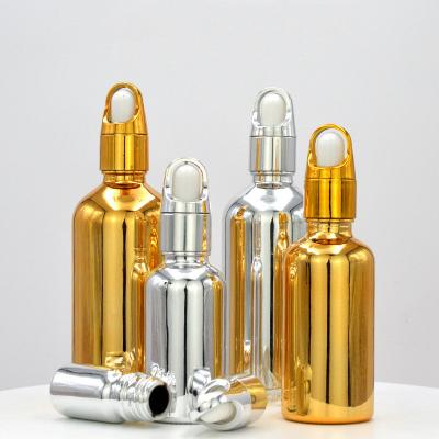 China Customized Accepted Essential Oil Small Round Empty Shiny Silver Gold Dropper Oil Bottle with Unique Flower Basket Rubber for sale