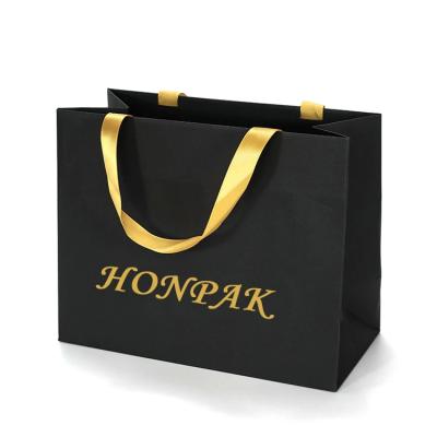 China Op maat gemaakte private warm stempen folie goud logo gedrukt kleine zwarte tas luxe boetiek kledingwinkel winkelen papier cadeautasjes Te koop