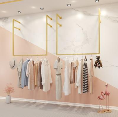 China Shiny Gold Hang Clothes Rack Stainless Steel Wall Mounted Shape Stand Morden Retail Clothing Store Boutique Garment Rack for sale