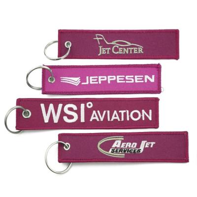 China All Hot Selling Custom Logo Move Flight Woven Key Tag Embroidered Keyring For Promotional Gifts for sale