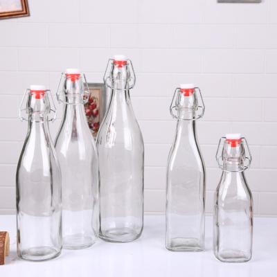 China Wholesale Beverage Air Tight Free Sample Clear Juice Glass Custom Kombucha Milk Bottles With Swing Cap for sale