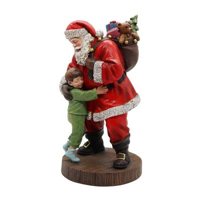 China Christmas Makers Sell Little Boys Hugging Santa Claus Wooden Grain Bases Resin And Stones for sale