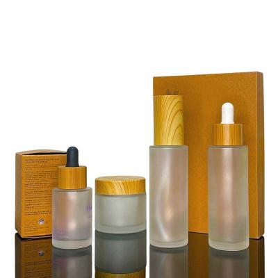 China 100ml Cosmetic Lotion Jars With Bamboo Lid Cosmetic Bottles With Wooden Cap Cosmetic Frosted Glass Bottle for sale