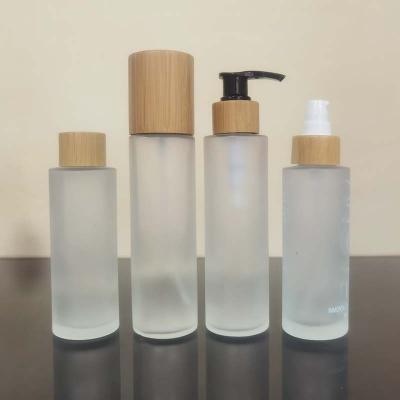 China Cosmetic eco friendly cosmetic packaging 30ml 50ml 100ml 150ml frosted bamboo bottles and pump jar with bamboo top for sale