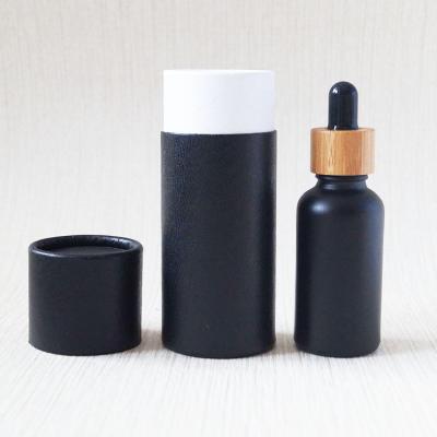 China Eco-friendly recyclable empty tinting oil packaging black frosted bamboo glass bottle 1oz 30ml serum dropper bottle with kraft paper tube for sale