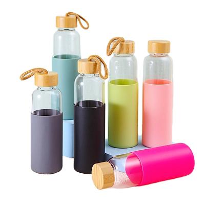 China Sustainable Factory Customized Recycled High Quality Handheld Logo Camping Frosted Glass Water Bottle With Lid&sleeves Bamboo Rope for sale