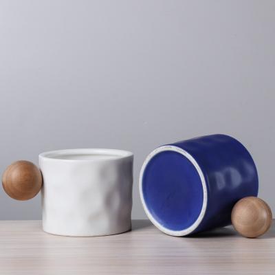 China 330ml Blue And White Ceramic Coffee Mug With Wooden Spherical Handle For Business Gifting for sale