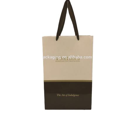 China Recyclable Gold Stamp Printed Chocolates Shiny Paper Bag With Ribbon Handles for sale