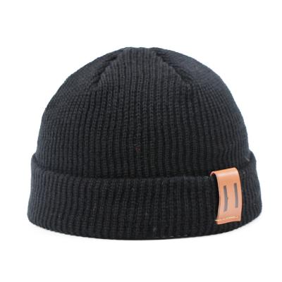 China Waterproof Knitted wool pullover hat for adults and children Stylish leather label woolen hat leather cap for sale