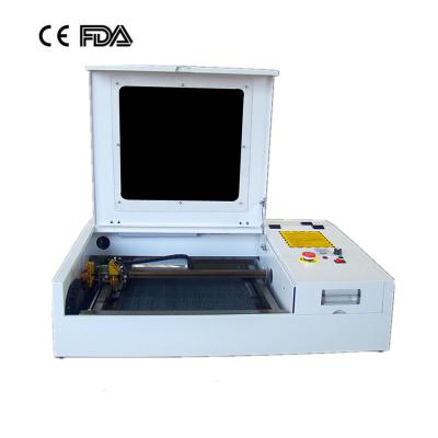 China 50w 4040 laser engraving cutting machine with CO2 laser tube and golden laser head for sale