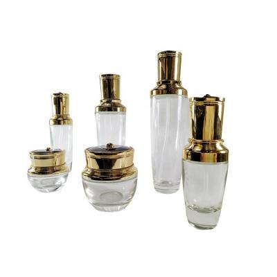 China Brand New Personal Care Factory Price Personal Care Cosmetic Packaging Transparent Glass Bottle And Jar Set With Gold Lid for sale