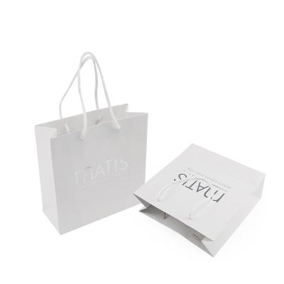 China Handmade Custom Logo Silver Stamp Good Quality Gloss Lamination White Paper Packaging Bags Wholesale for sale