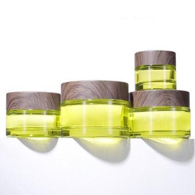 China LOW MOQ 10g 15g 30g 50g Personal Care Green Glass Cream Jar Bottle With Wood Grain Cap for sale