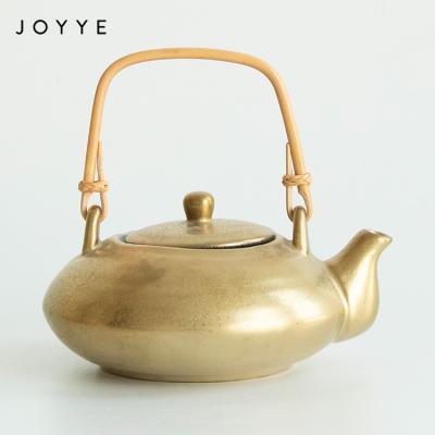 China Joyye Viable Unique Gold Ceramic Teapots Customized Handmade Decorative Ceramic Teapot With Rattan Handle for sale