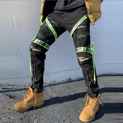 China 2021 QUICK DRY In Street Fashion Hip Hop Running Jeans Pants With Ribbons Letter Print Ripped Pencil Jeans Men Slim Fit for sale