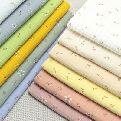 China Anti-Static Cheap light weight soft stocklot custom printed 100% cotton double layers gauze crinkle muslin fabric for baby cloth swaddle for sale