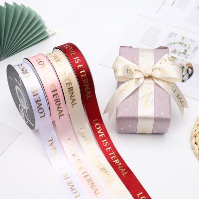 China Holographic Tan LO VE IS ETERNAL Satin Ribbon Valentine's Day Flower Wrapping Ribbon Gift Wrapping Decorative Ribbons for sale