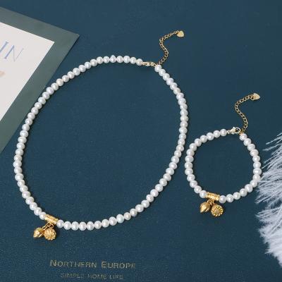 China Elegant lady style 2021 retro gold plated style cooper lotus pendants near round pearl bracelet necklace set for girls for sale