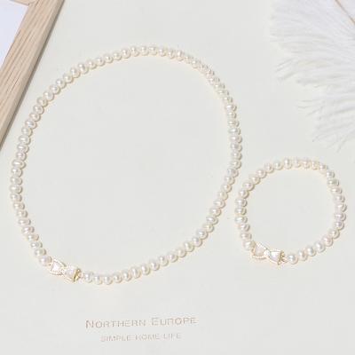 China New Design Cooper Ethnic Elegant Gold Plated Bowknot Clasp Near Round Pearl Necklace Bracelet Set For Women for sale