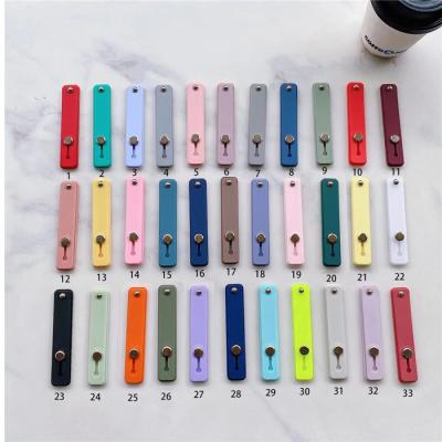 China Universal Adjustable Candy Color Mobile Phone Wrist Band Phone Grip Holder White Silicone Finger Grip Strap Grip for sale