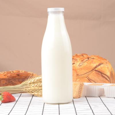 China Wholesale Viable Round Glass Milk Bottle Transparent Customized Glass Bottle For Milk With Plastic Lid for sale