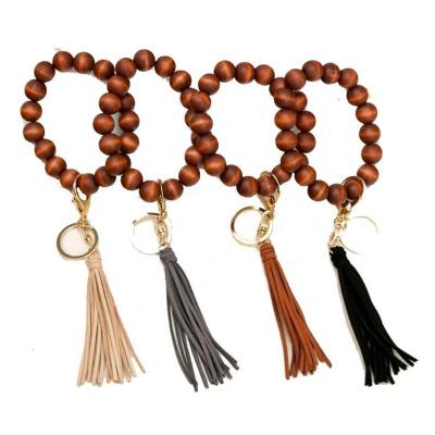 China Suede Handmade Wooden Beads Stretch Bracelet Tassel Keychain Personalized Beaded Elastic Tassel Wooden String Bracelet Keychains for sale