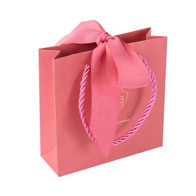 China 250gsm Recyclable Elegant Custom Premium White Cardboard Paper Ribbon Gift Shopping Bags With Handle for sale