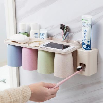 China Eco-Friendly Toothpaste Holder Toothbrush Holder Auto Sustainable Plastic Wall Mounted Organizer Toothpaste Dispenser For Family Bathroom for sale