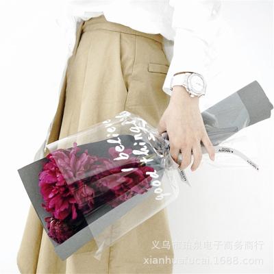 China OPP transparent waterproof sandpaper plastic packaging florist dustproof moistureproof bouquet gift wrapping paper with letter for sale