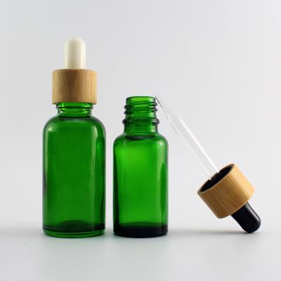 China Cosmetic Essential Oil Green Blue Amber Clear Glass Bottle With Bamboo Lid for sale