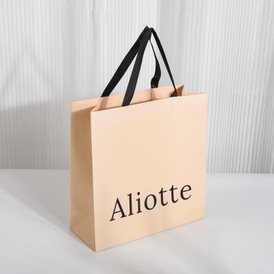 China Custom Clothing Packaging Black Kraft Paper Bag with Logo and Recyclable Handle Types for sale