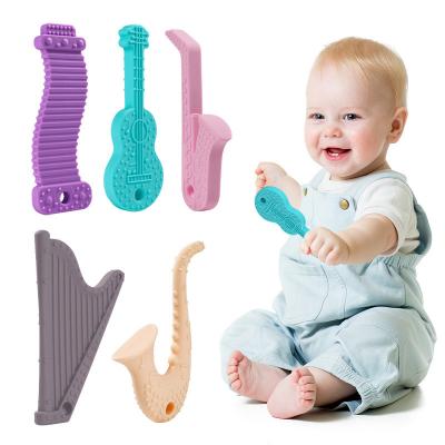 China 100%food Grade Silicone 2022 New Food Grade Soft Silicone Guitar Musical Instrument Shape Model Baby Teether Teething Relief Toys for sale