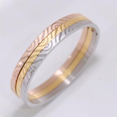 China Fashionable Women Stainless Steel Gold Ripple Wave Swirl Custom Copy Stamped Bangle Bracelet for sale