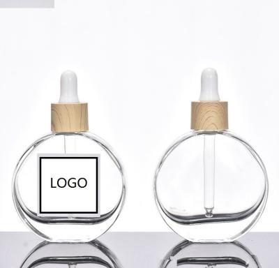 China Cosmetic Luxury Designer 50ml Flat Round Skincare Refill Glass Serum Essential Oil Dropper Bottle with Bamboo Ring for sale