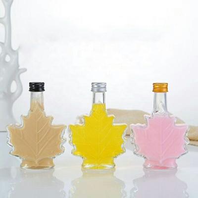 China Unique 100ml Beverage Maple Leaf Shaped Glass Bottles Glass Beverage Bottle Dark Rum Bottle With Screw Cap for sale